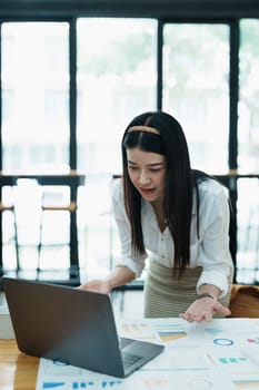 Portrait of a beautiful Asian teenage girl using computer for video conferencing at office.