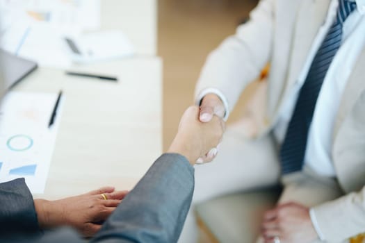 Asian entrepreneurs handshakes to congratulate the agreement between the two companies to enhance investment and financial strength. deal concept.