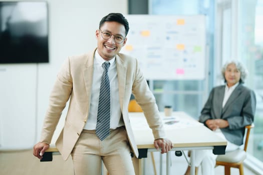 Portrait of a male business owner showing a happy smiling face as he has successfully invested his business using computers and financial budget documents at work.