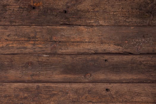 Several horizontally stacked old boards in clothes of brown color. Background of natural material slightly tattered.