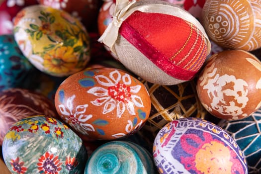 Close-up view from above. Randomly stacked close together, the Easter eggs form a colorful Easter composition while tightly filling the entire frame.