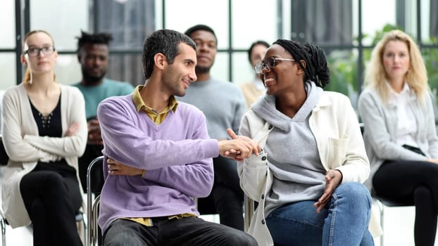Selective focus of young businesswoman applauding together with interracial colleagues during seminar