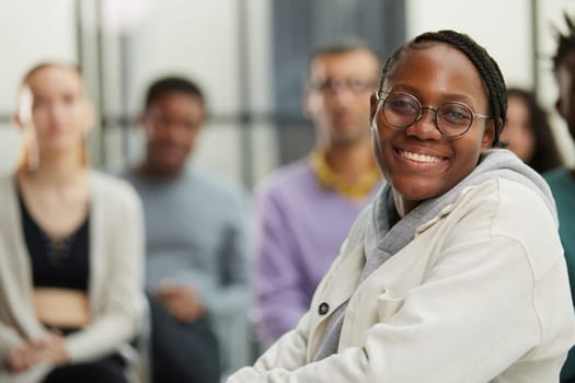 Thoughtful african american female freelancer looking at camera in front of her colleagues