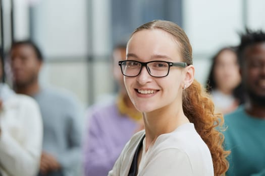 young attractive business woman, teacher or trainer-mentor, looking at the camera