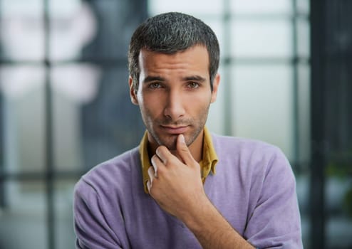 Portrait of businessman standing in office while working day