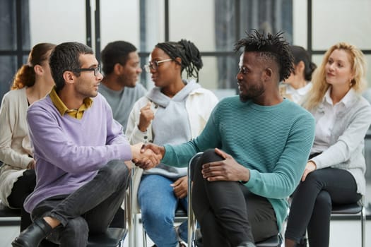 Positive people sitting on a chair, taking part in a team building or therapy session, trying to solve problems or doing training exercises