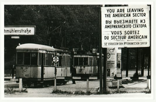 BERLIN, GERMANY - CIRCA 1950s: Vintage photo shows checkpoint between west (American sector) and ost Berlin. Tram leaves American sector.