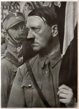 GERMANY - 1935: Adolf Hitler holds a standard during the Party Congress of the NSDAP in Weimar Republic. Reproduction of antique photo.