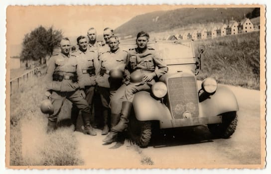 GERMANY - CIRCA 1940s: Vintage photo shows German Nazi soldiers stand at convertible.