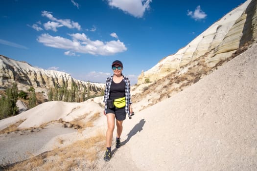 Woman standing on sandy mountain hill in sunny Cappadocia, Turkey