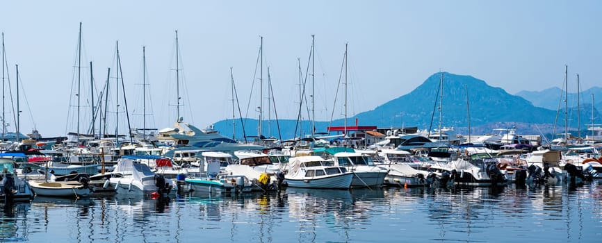 Yachts port in Montenegro with mountains view and forest in adriatic sea. Boats pier in sunny day with beautiful Mediterranean nature