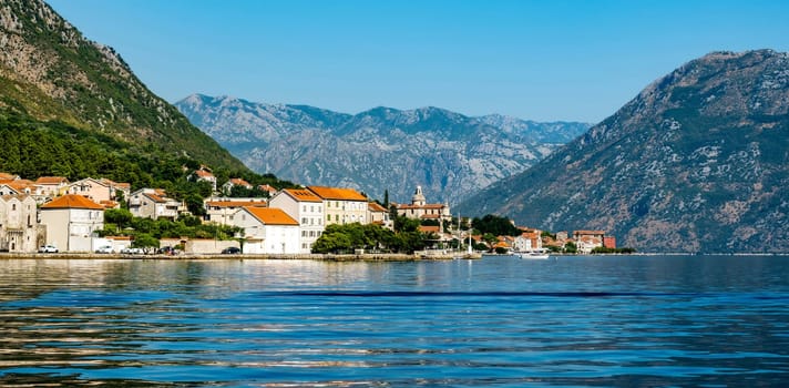Beautiful city in Adriatic sea in Montenegro with mountain view in summer sunny dy. Scenic town with nature landscapes