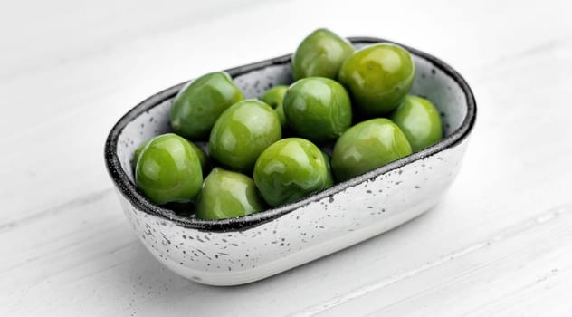 Sweet green olives in plate, mediterranean vegetarian delicatessen. Delicious snack appetizer from Greece
