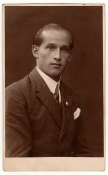 LIBEREC (REICHENBERG), THE CZECHOSLOVAK REPUBLIC - CIRCA 1920s: Vintage photo shows young man wears jacket. Antique black white studio portrait.