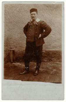 FALKENBERG, SWEDEN -MARCH 24, 1907: Vintage photo shows man wears traditional clothing, he stands in the back yard. Antique black white photo.