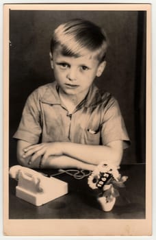 THE CZECHOSLOVAK SOCIALIST REPUBLIC - 1963: Vintage photo shows a young boy with children's telephone. Black white retro photo.