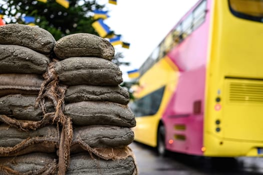 Sacks with sand at Checkpoint Charlie against hop-on hop-off touristic bus. The crossing point between East and west Berlin, symbol of the Cold War.
