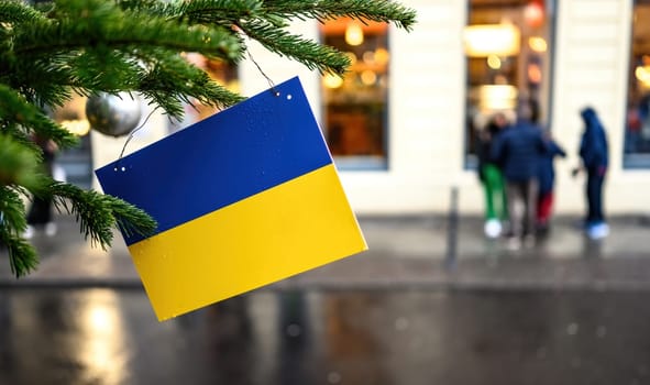 Ukrainian flag on a Christmas tree against city steet