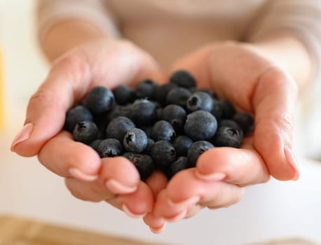 Girl holding blueberry in hands, Handful of berries