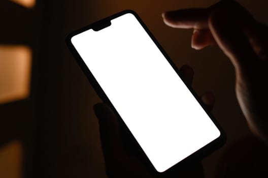Hands holding a smart with white screen against blurry background