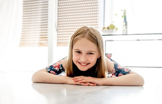 Portrait of smiling cute little girl lying on the floor