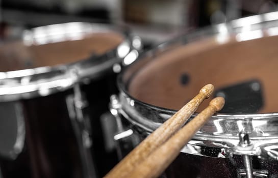 Drumsticks and drums for live music rock perfomance closeup. Wooden musical sticks for percussion instruments