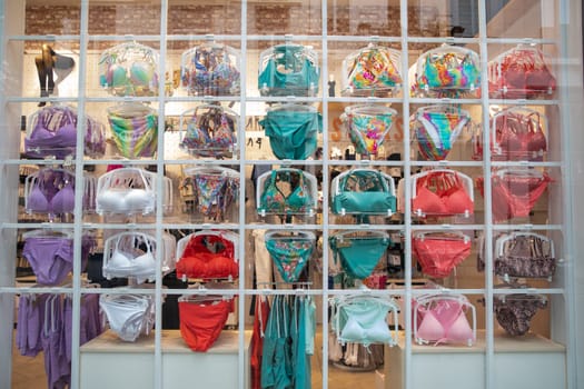 Swimsuits hanging on rack in lingerie store, selective focus. Concept of shopping, sale, female fashion for summer vacation. High quality photo