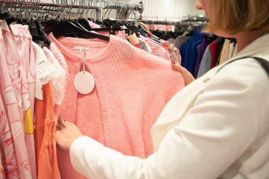 girl in the store chooses on a hanger pink blouse, color millennial, beauty fashion clothes, High quality photo