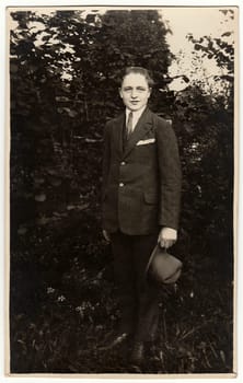 THE CZECHOSLOVAK REPUBLIC - CIRCA 1940s: Vintage photo shows man wears suit with an elegant hat poses outdoors. Black white antique photo.