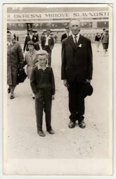 THE CZECHOSLOVAK SOCIALIST REPUBLIC - CIRCA 1960s: Vintage photo shows father and son pose at the socialist celebration. Black white antique photo.