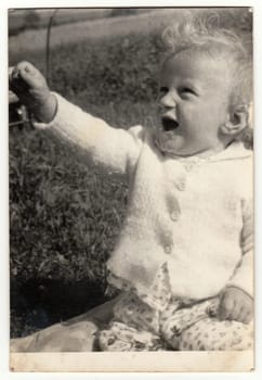 THE CZECHOSLOVAK SOCIALIST REPUBLIC - CIRCA 1980s: Vintage photo shows baby boy outdoors. Antique black white photo.