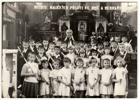 THE CZECHOSLOVAK SOCIALIST REPUBLIC - CIRCA 1960s: Vintage photo shows children and pastor in the church. Antique black white photo.