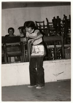 THE CZECHOSLOVAK SOCIALIST REPUBLIC - CIRCA 1980s: Vintage photo shows boy makes fun, he wears an apron. Antique black white photo.