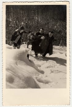 THE CZECHOSLOVAK SOCIALIST REPUBLIC - CIRCA 1960s: Vintage photo shows people frolic in the snow. Black white antique photography.