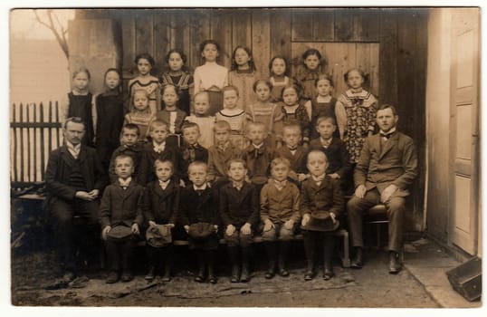 THE CZECHOSLOVAK REPUBLIC - CIRCA 1930s: Vintage photo shows pupils (schoolmates) and teachers in the rural back yard. Black white antique photography.