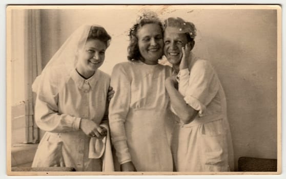 THE CZECHOSLOVAK REPUBLIC - CIRCA 1930s: Vintage photo shows nurses, one of them prepares to wedding ceremony . Black white antique photography.