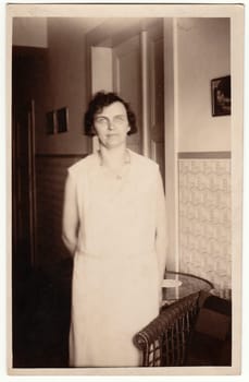 THE CZECHOSLOVAK REPUBLIC - CIRCA 1940s: Vintage photo shows woman poses at her home. Black white antique photo.