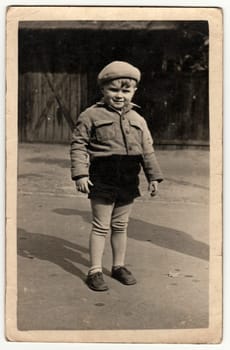 THE CZECHOSLOVAK SOCIALIST REPUBLIC - CIRCA 1950s: Vintage photo shows a small boy poses in the back yard. Black white antique photo.