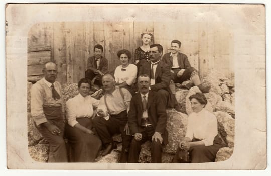 LINZ, AUSTRIA-HUNGRAY - AUGUST 8, 1913: Vintage photo shows group of people sit in the back yard. Black white antique photography.