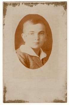 THE CZECHOSLOVAK REPUBLIC - CIRCA 1930s: Vintage photo shows face of boy (portrait). Antique black white photo is oval shaped.