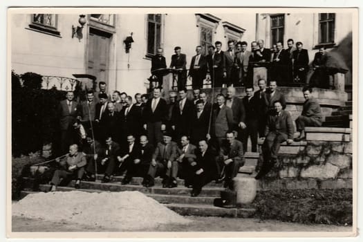 THE CZECHOSLOVAK REPUBLIC - CIRCA 1950s: Vintage photo shows a big group of men stand in front of historic building. Antique black white photography.