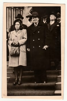 PRAGUE, THE CZECHOSLOVAK REPUBLIC - 1946: Vintage photo shows newlyweds stand on stairs after wedding ceremony. Black white antique photography.