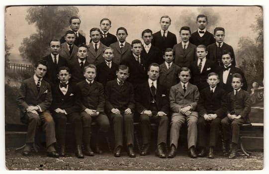 PRAGUE, THE CZECHOSLOVAK REPUBLIC - MARCH 15, 1920: Vintage photo shows young men (students) with teacher. Black white antique photography.