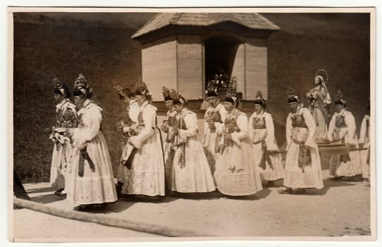 GERMANY - CIRCA 1930s: Vintage photo shows young women during religion procession. Women wear folk costums. Black white antique photography.