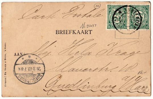 AMSTERDAM, THE NETHERLANDS - MARCH 28, 1903: Back of a vintage photo - used postcard. Rich stain and paper details. Can be used as background. Image contains handwriting.