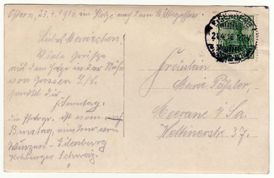 GERMANY - APRIL 23, 1916: Back of a vintage photo - used postcard. Rich stain and paper details. Can be used as background. Image contains handwriting.