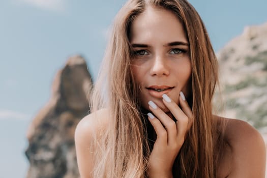 Woman travel sea. Young Happy woman in a long red dress posing on a beach near the sea on background of volcanic rocks, like in Iceland, sharing travel adventure journey