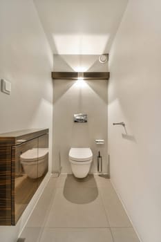 a modern bathroom with white walls and wood cabinets on either sides, along the wall is a mirror above the toilet