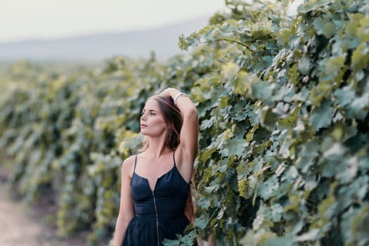 Woman at autumn winery. Portrait of happy woman holding glass of wine and enjoying in vineyard. Elegant young lady in hat toasting with wineglass smiling cheerfully enjoying her stay at vineyard
