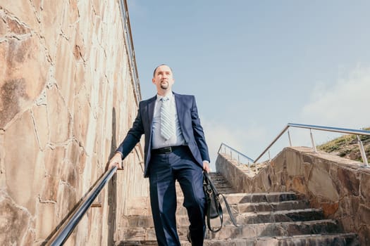 Business executive with briefcase going down the stairs.